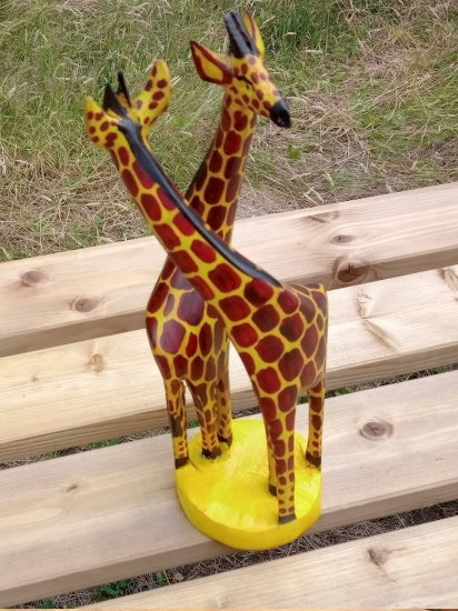 Pair of carved wooden giraffes on a stump