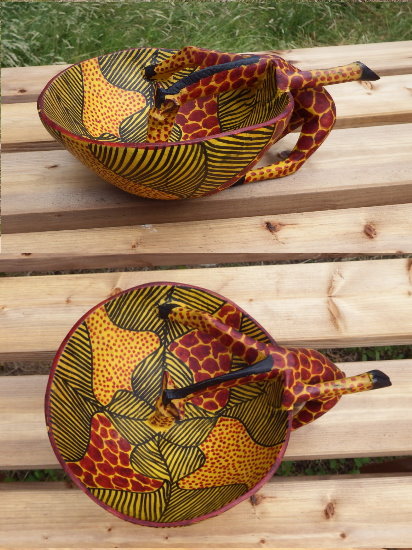 Wooden giraffe ornament drinking from a bowl